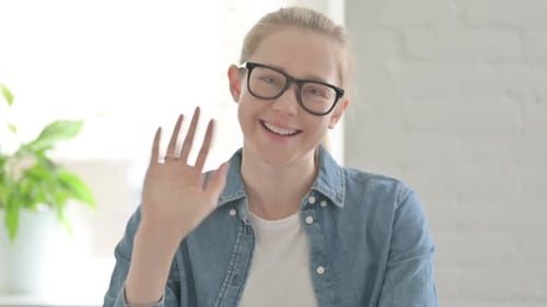 Junge Frau winkt mit der Hand, um Hallo zu sagen