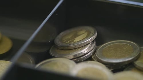 Close-up of Euro coins in a drawer reflecting subtle lighting