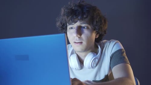 Young Adult Interacting with Laptop Computer at Night