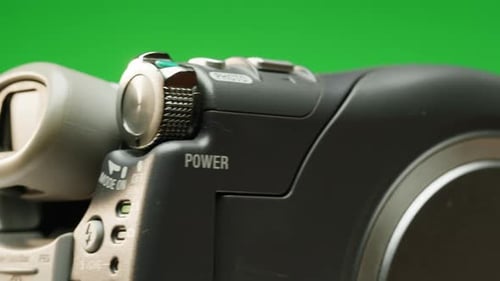 Videocámara vintage con disco interior que gira sobre fondo verde, primer plano con videocámara portátil