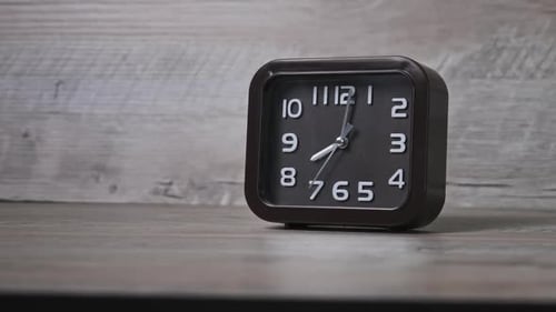 The Pointer Clock of Square Shape on Wooden Table Shows Time 8 Hours