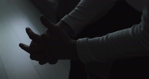 Hands Clasped in Dim Light