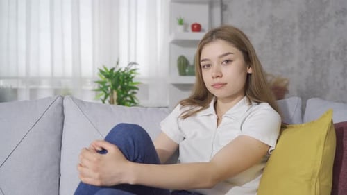 Young Blonde Woman Sitting on Couch Indoors
