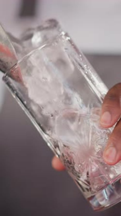 Ice Being Poured into Glass Cup