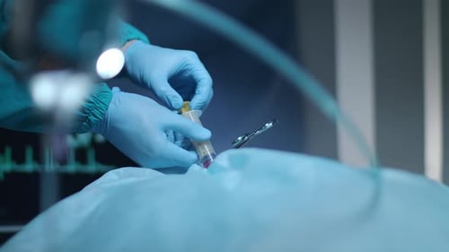 Surgeon Performing Medical Procedure Using Syringe and Scalpel