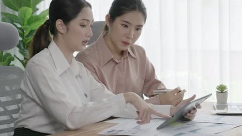 Deux jeunes femmes d'affaires enthousiastes travaillant ensemble dans l'espace de travail