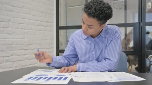 Young African Woman Working on Documents in Office