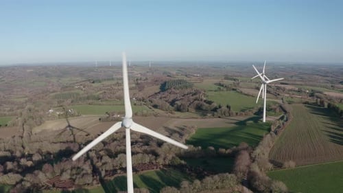 una serie de molinos de viento generadores de energía giratorios se extiende en la distancia