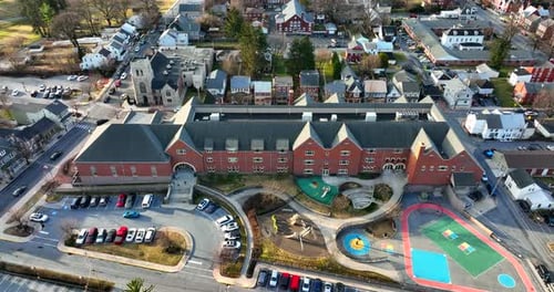 Vue aérienne de l'établissement d'une école primaire publique. Bâtiment en briques rouges et terrain de jeu peints pour