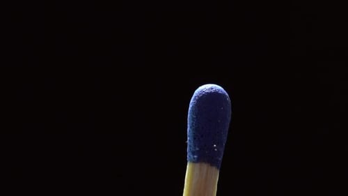 Close-up of a Blue Matchstick Head Isolated on a Black Background