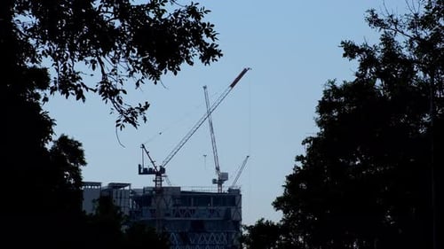 La cámara se aleja y revela este escenario de silueta de Cranes and Construction, Bangkok, Tailandia