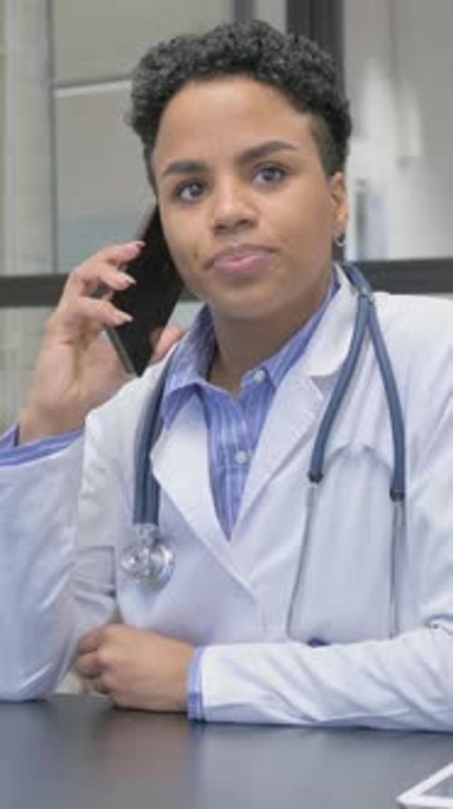 Woman in Lab Coat Talking on Mobile Phone