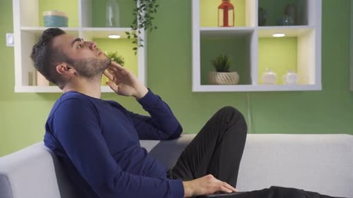 Man Sitting on Couch Thinking Indoors