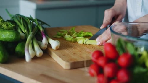Cooking Fresh Salad Mix With Onion, Cucumber And Radishes. Close Up Woman Hands Cutting Green Oni...