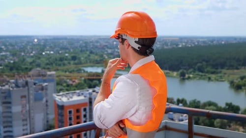 Engineer Looking Out at the City from High Rise