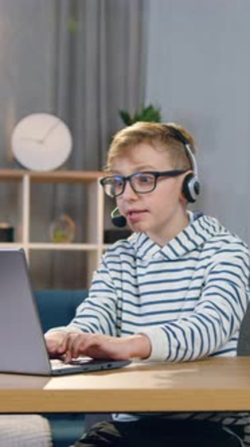 Excited Boy Plays Video Game at Computer at Home
