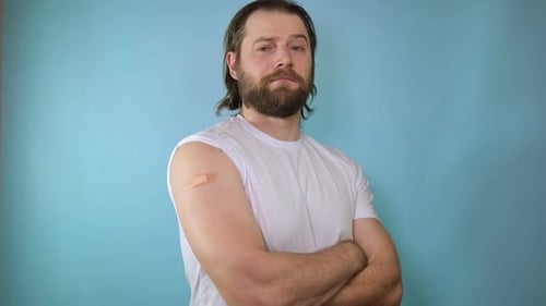 Man with Bandage on Arm After Vaccine