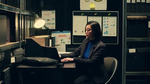 Woman Puts Laptop in Bag after Late Work