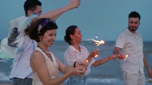 Friends Celebrating with Sparklers on a Beach at Night