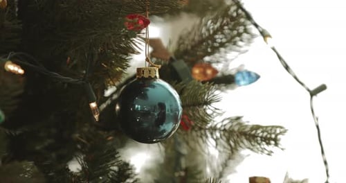 Blue Ornament Swinging Hanging From Christmas Tree Branch
