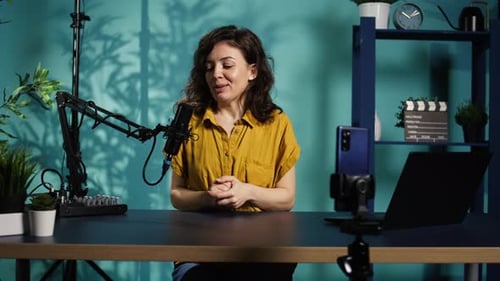 Woman Hosts Podcast at Desk with Equipment