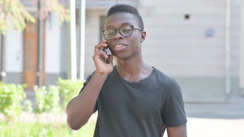 Young Man Talking on Mobile Phone Outdoors
