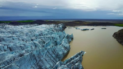 Aerial View Of Svinafellsjokull Glacier With Crack Blue Ice And Veins of Black Ash In Iceland.
