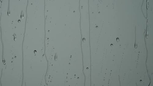 Rain Drops Flowing Down Window Glass