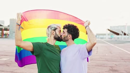 Gay Couple Kissing Behind Rainbow LGBT Pride Flag