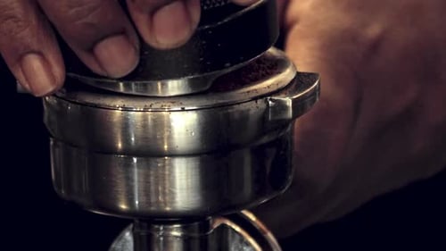 Coffee Grounds Being Pressed by Barista's Hands