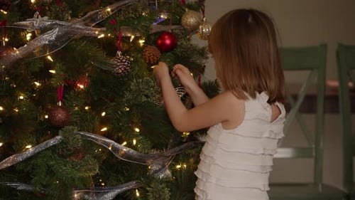 Young Girl Decorating Christmas Tree with Ornaments