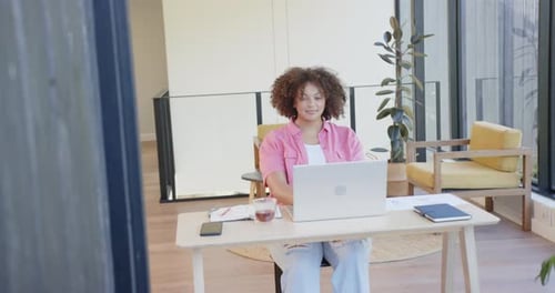 Stretching arms, plus size woman taking break from work at home office desk