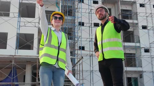 Construction Workers Discuss Building Project Outdoors
