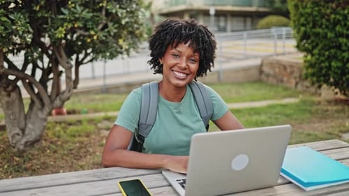 Smiling Student Working on Laptop in Park