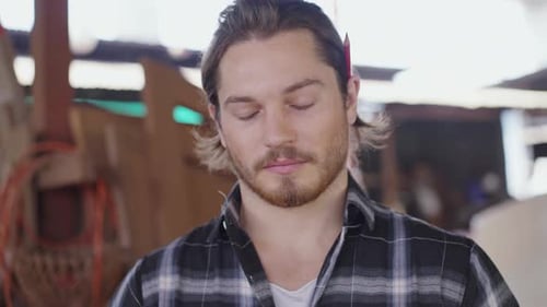 Portrait of male carpenter in arms crossed with equipment at carpentry workshop