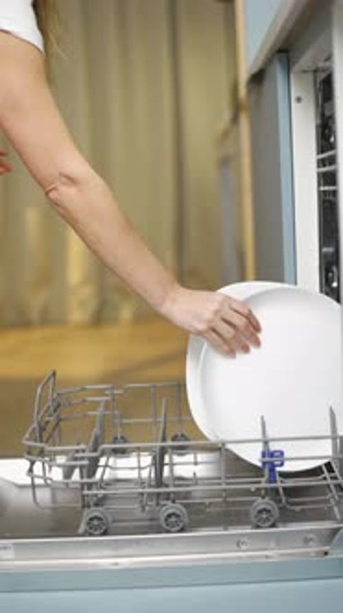 Home Kitchen Woman Puts Plates and Dishes in the Dishwasher Home Kitchen Dishwashing Process