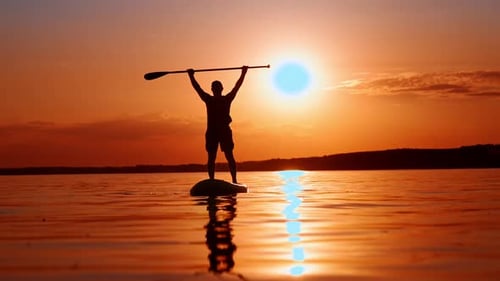 Person Paddle Boarding during a Beautiful Sunset