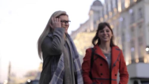 Two happy female friends enjoying shopping time together in London