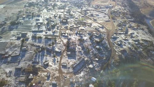 Drone, landscape and rural town in the mountains with equipment on the ground for building