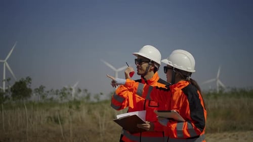 Engineers work at windmill farm.