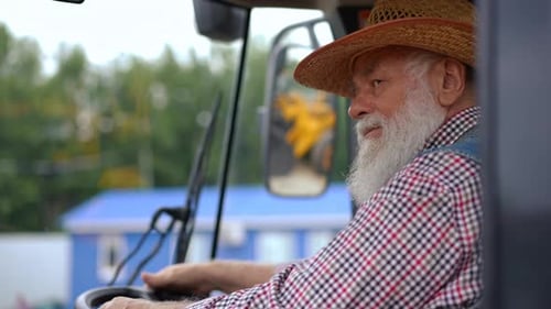 Senior Man Smiling in Tractor Cab Close Up