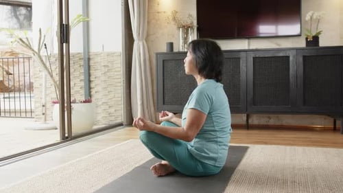 Woman Meditating on Yoga Mat Indoors