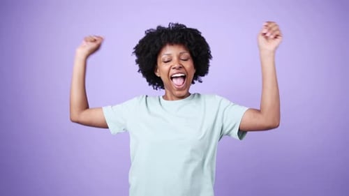 Young Woman Dancing and Having Fun on Purple Background