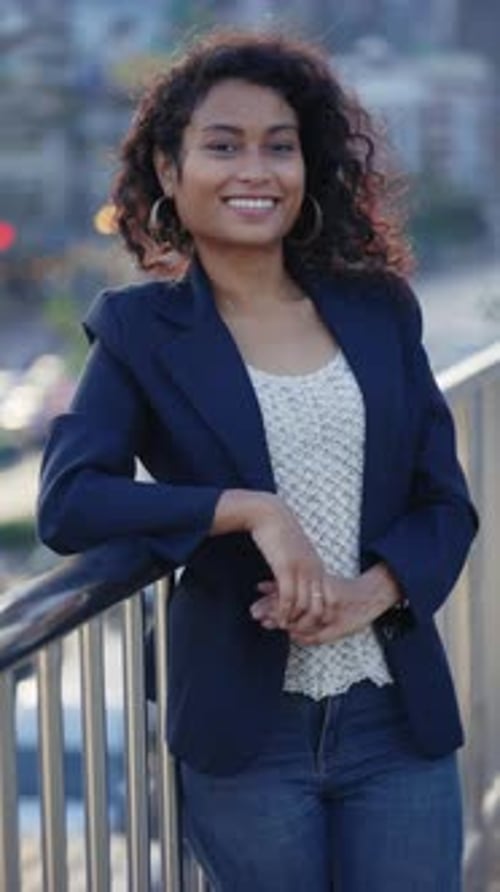 Vertical Video Smiling Woman Leaning on a Bridge and Smiling at the Camera
