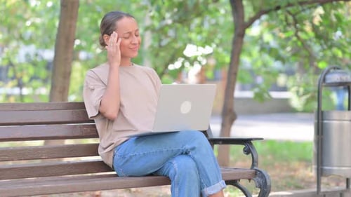 Woman on Bench Works on Laptop in Park