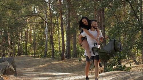 Couple Hiking in Woods, Woman Rides Piggyback