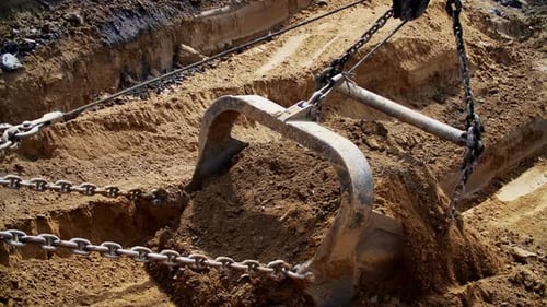 Excavator Bucket Lifting Dirt into Truck at Quarry