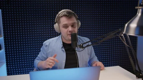 Radio Host Sit in Studio and Communicates with Audience Man in Blue Shirt and Headphones Sits in