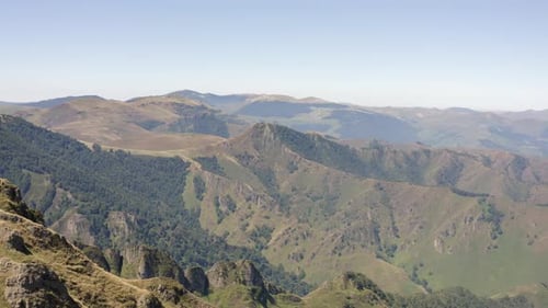 Flyover unspoiled misty mountain landscape, rugged green terrain
