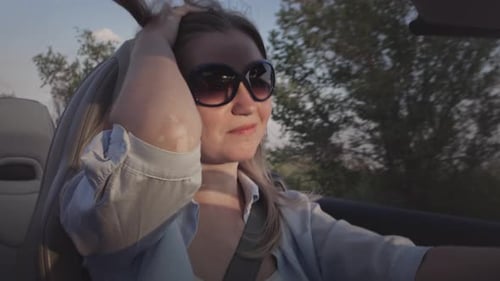 Junges schönes Mädchen fährt im Sommer einen Cabrio-Sportwagen